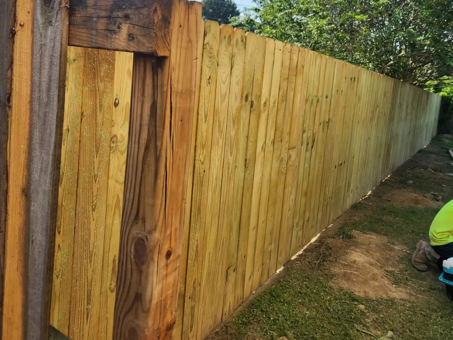 A wood privacy fence along a backyard, on one of Dario’s jobs