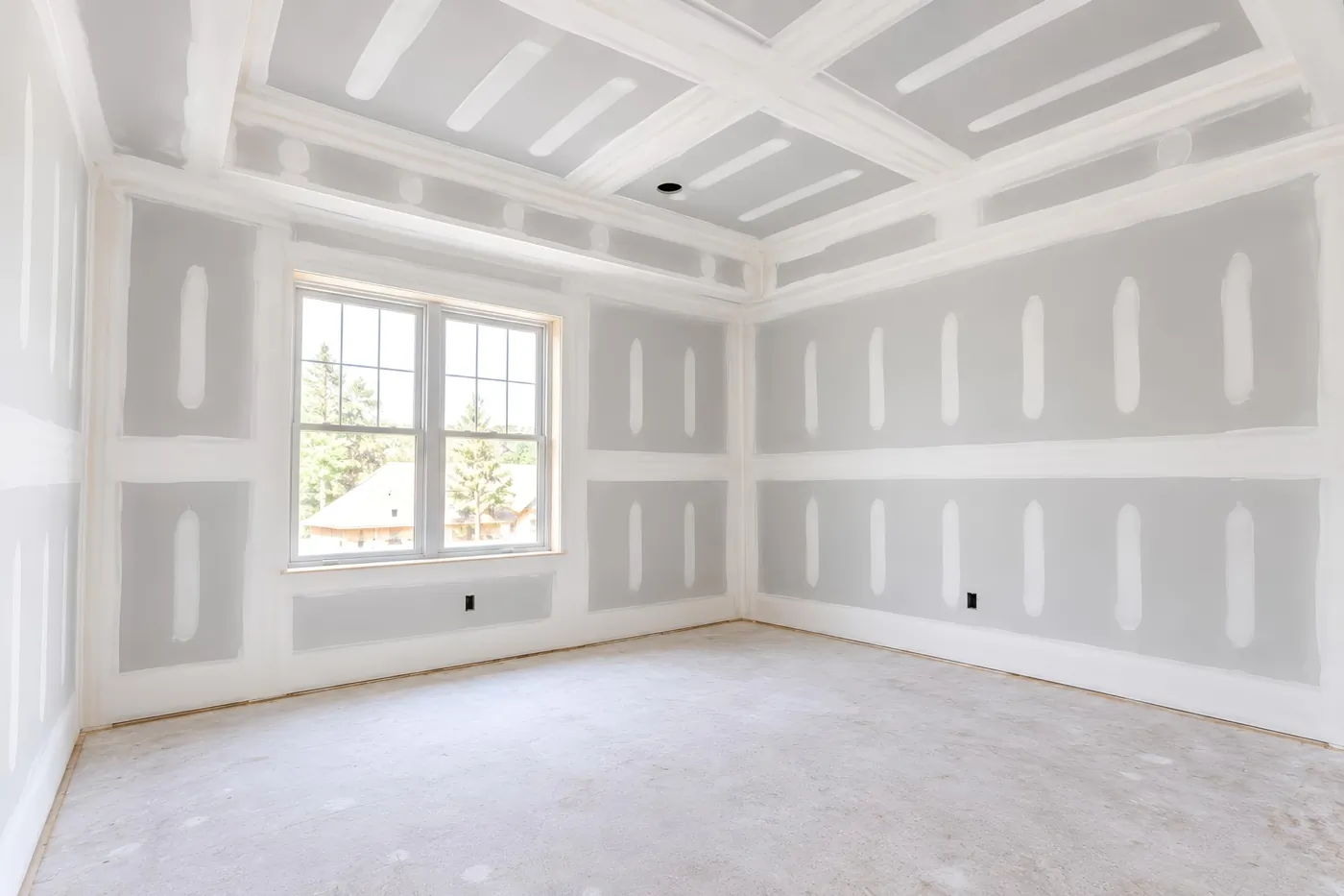 A room with new drywall taped and mudded, ready for sanding, primer and paint