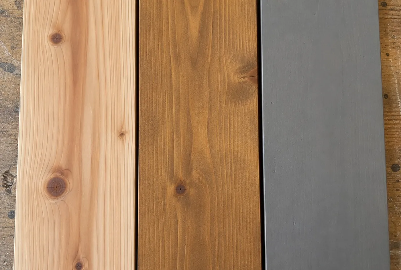 Three cedar boards: clear stain, semi-transparent brown stain and solid grey stain