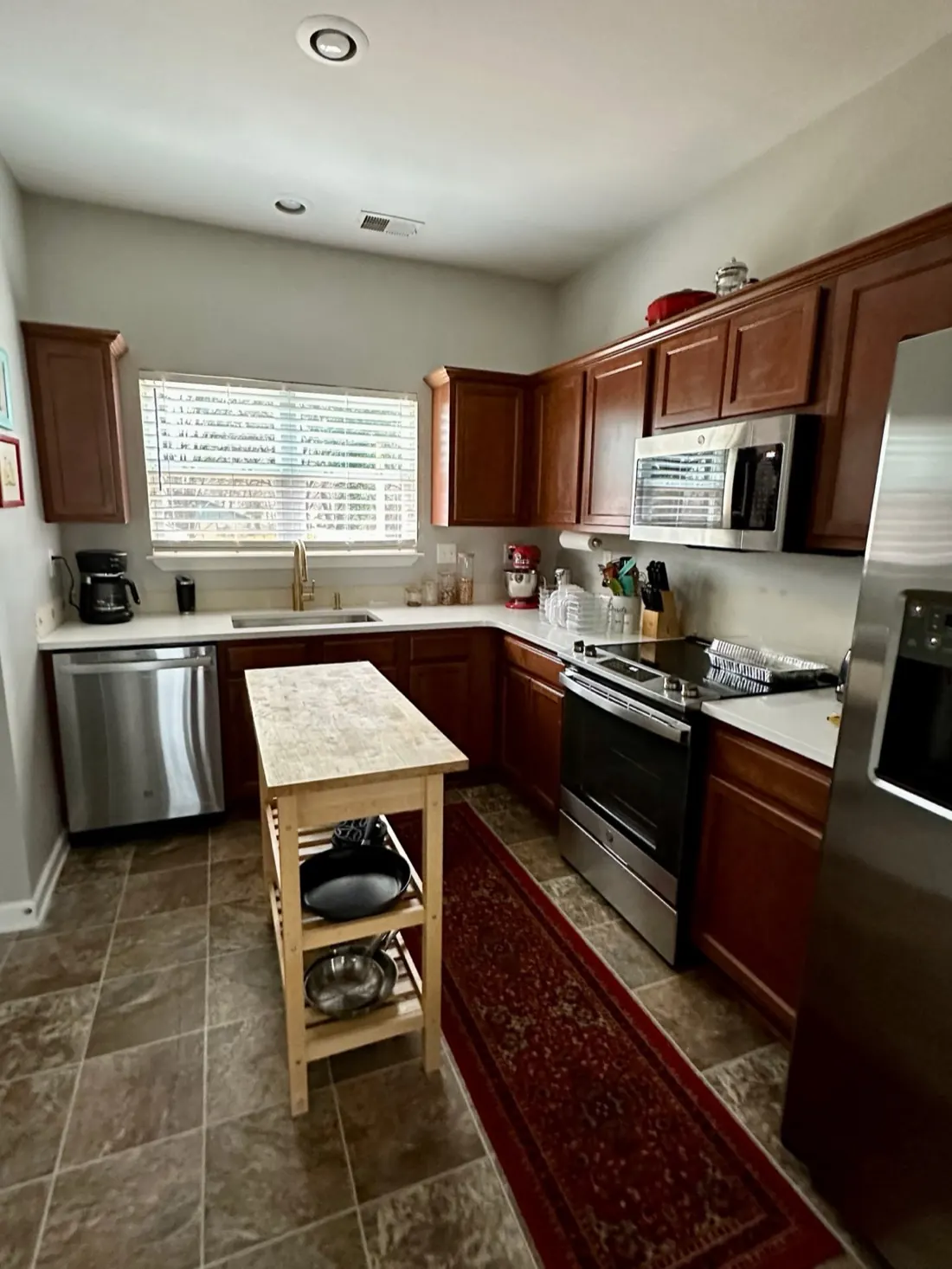 A kitchen with dark cherry-stained cabinets before refinishing
